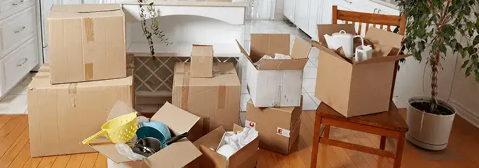 Packed moving boxes and household items in a kitchen before move-out or move-in cleaning, Houston, TX.